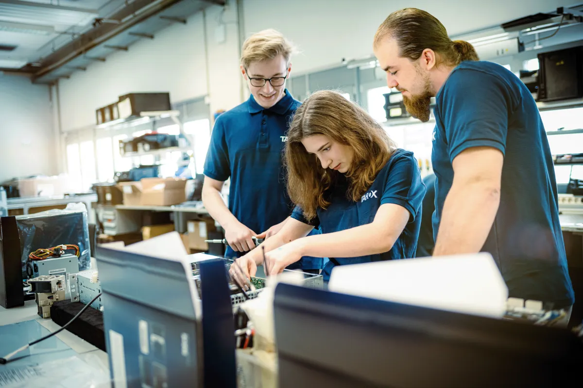 Dein Karrierestart – Deine Ausbildung bei TAROX. Foto von 2 Auszubildenden, die unter Anleitung an der Fertigung eines Servers arbeiten.
